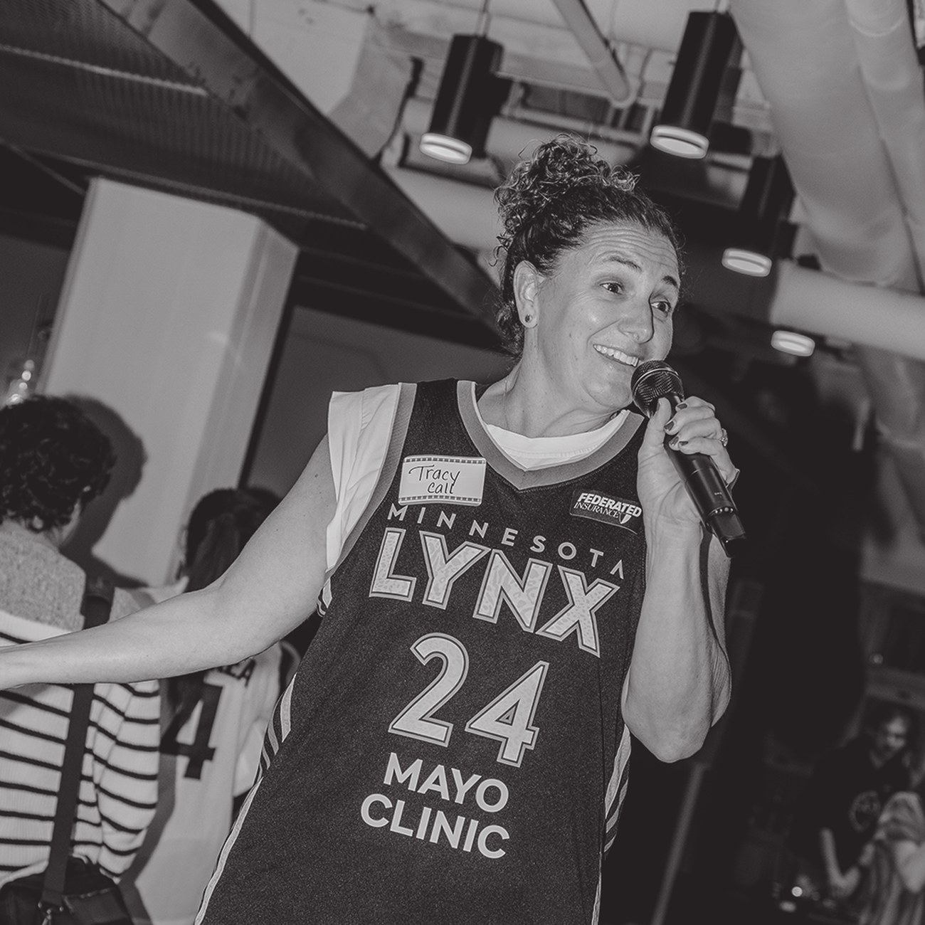 Tracy Call speaking into a microphone at a Minnesota Lynx event
