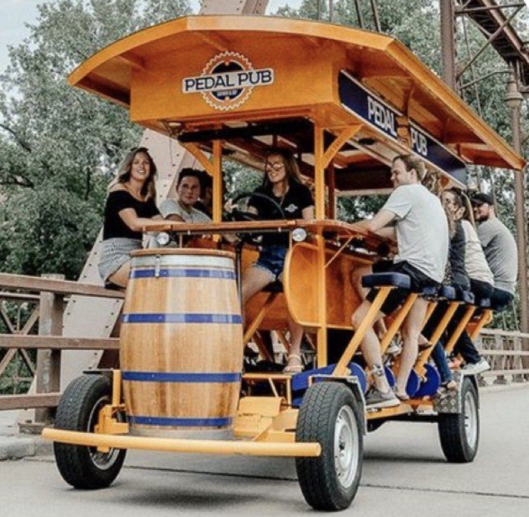 A Pedal Pub full of riders on the Stone Arch Bridge